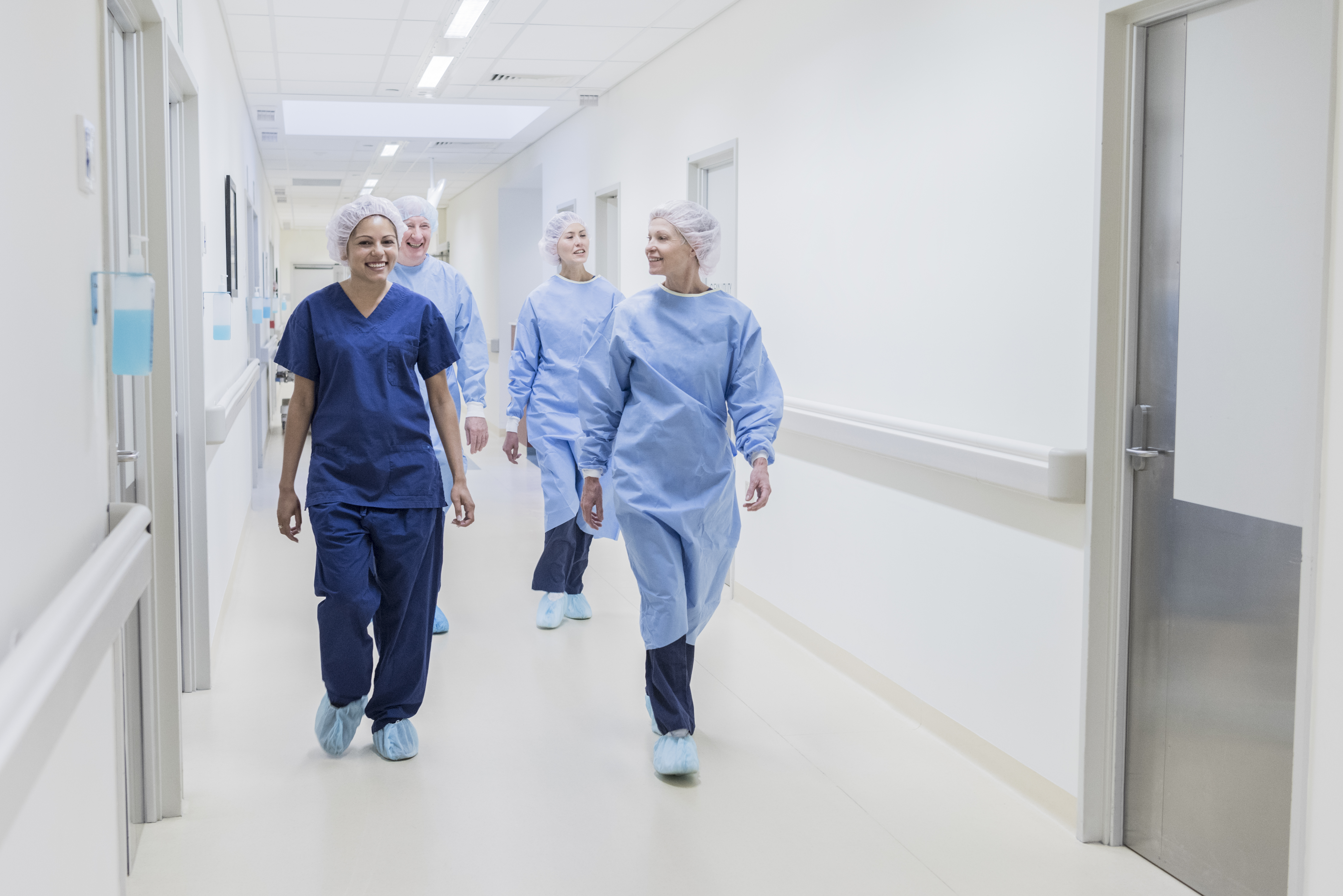 People walking down a corridor wearing hospital scrubs