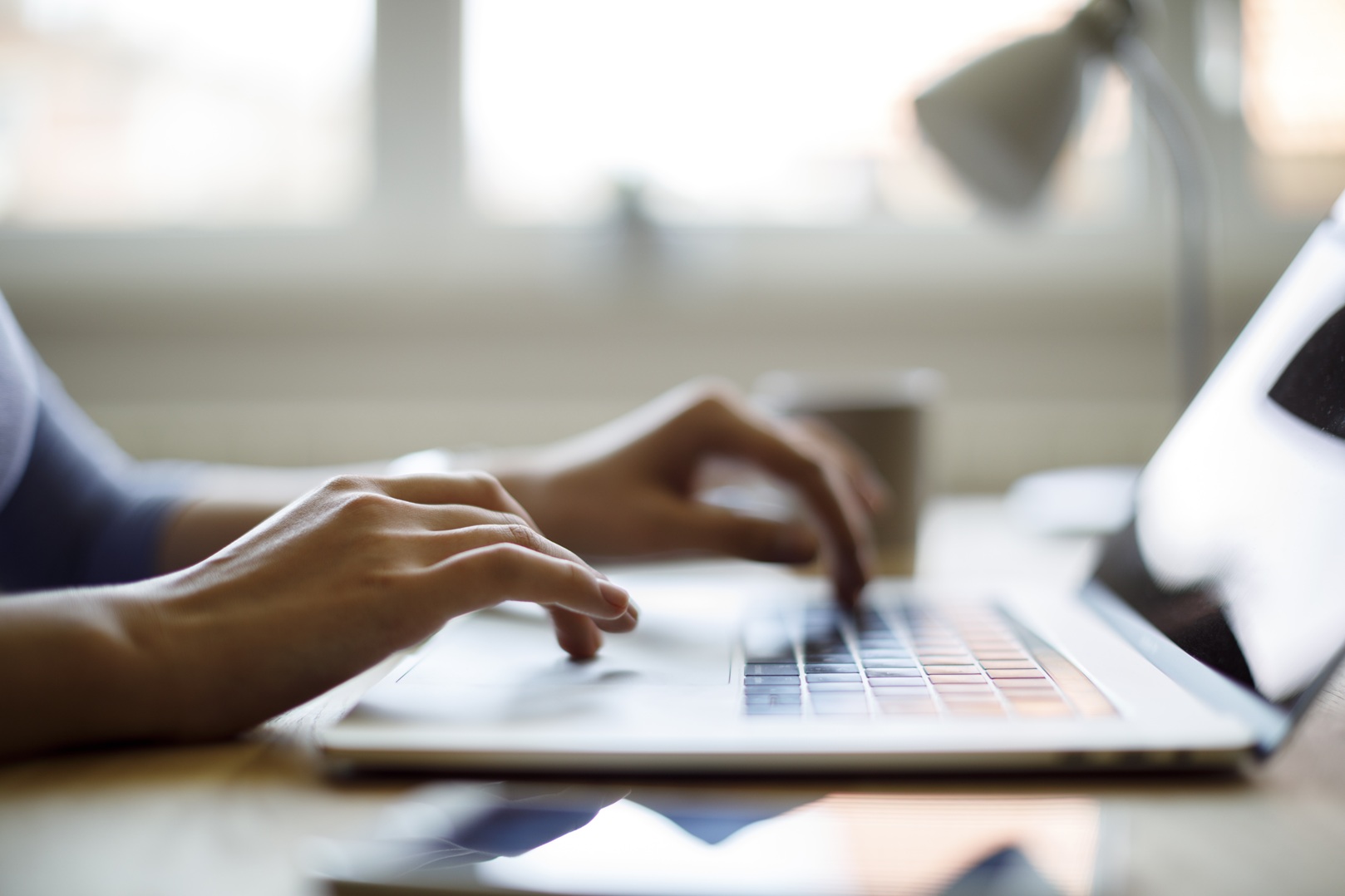 Hands typing on a laptop